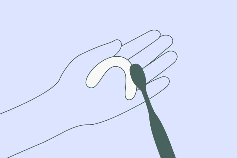 Illustration of hand holding clear aligner and using a toothbrush to clean.